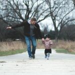 Dad and daughter enjoying a walk in the park, symbolizing love and togetherness.