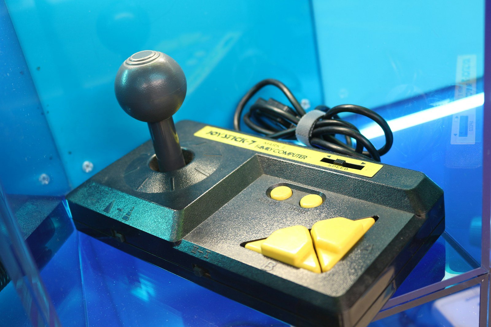 A display case with a game controller and a piece of cheese