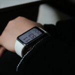 A person wearing a smartwatch with white band.