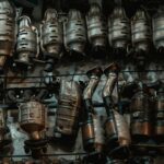 Rows of used catalytic converters in an automotive workshop setting.