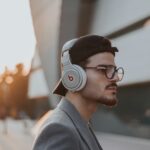 shallow focus photography of man wearing Beats wireless headphones