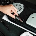 A person cutting a piece of plastic with a pair of scissors