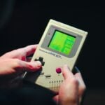 person holding gray nintendo game boy