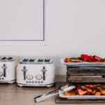 Modern kitchen scene with toasters and assorted fruit trays on a countertop.