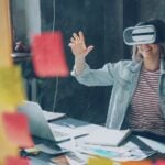 Woman happily experiencing virtual reality at her desk.
