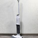 A floor sweeper sitting on top of a hard wood floor