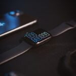 a cell phone sitting next to a smart watch