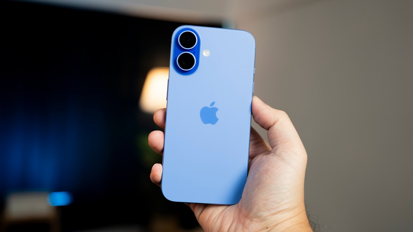 A person holding a blue iPhone in their hand