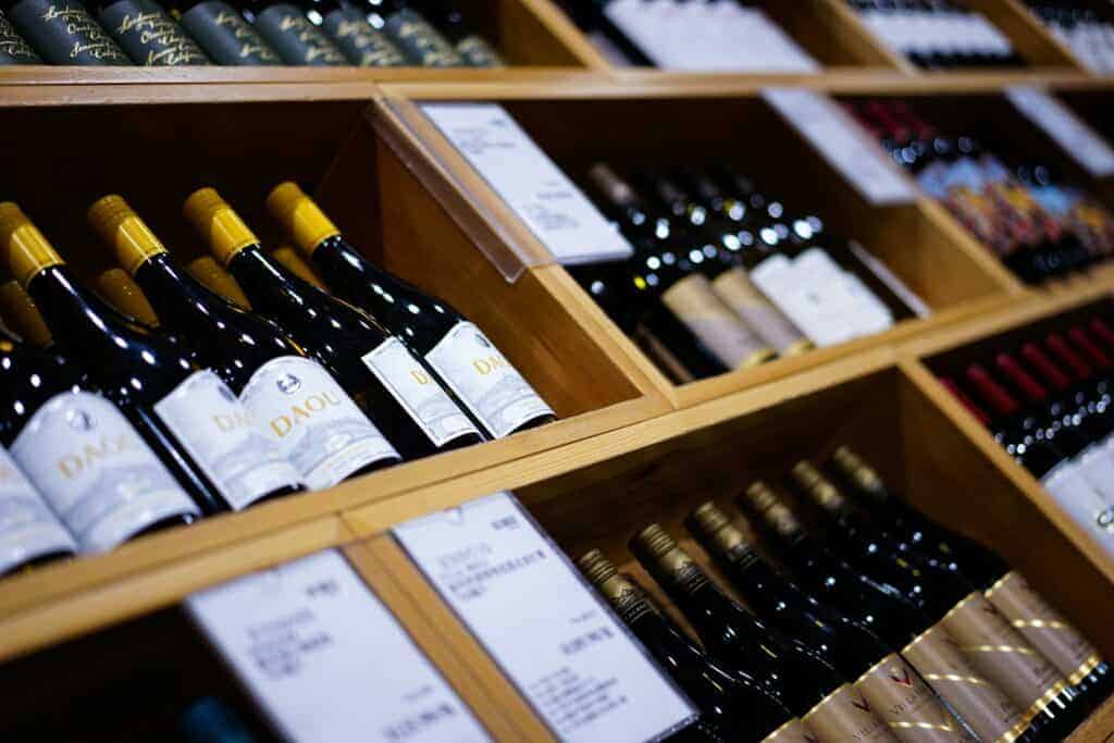 a bunch of wine bottles that are on a shelf