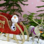 white dog figurine on red and brown textile