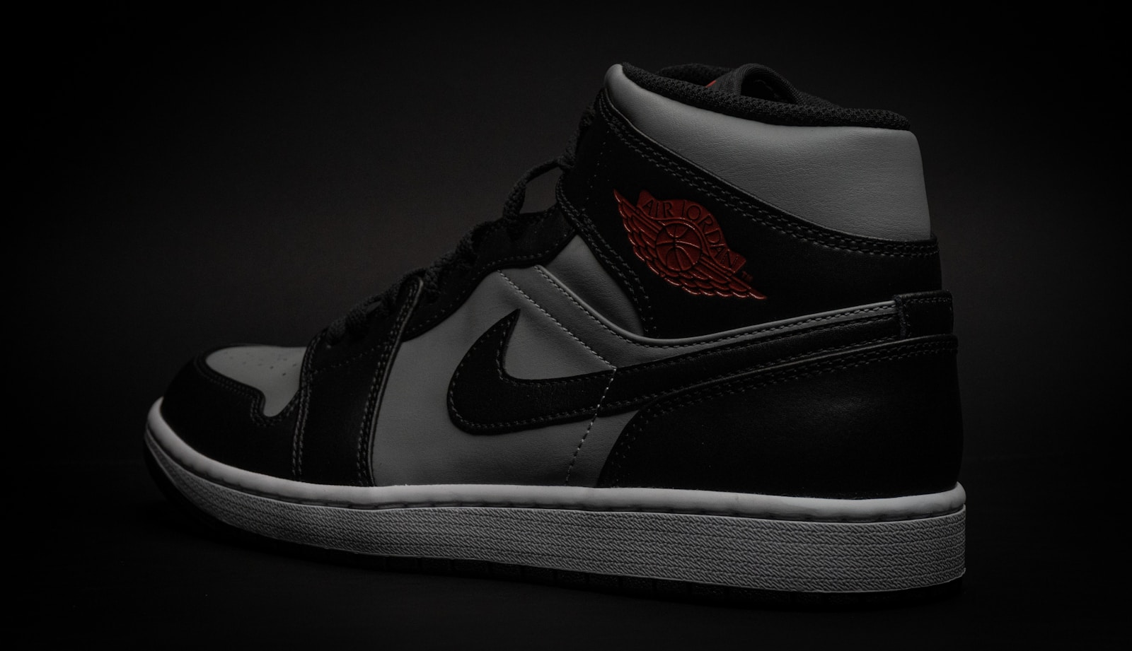 a pair of black and white sneakers on a black background