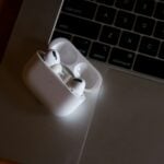 white apple earpods on gray laptop computer