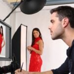 man in black dress shirt holding woman in red sleeveless dress