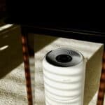 a white air conditioner sitting under a table