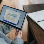 person in blue denim jeans holding Windows 11 tablet