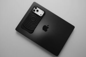 Black smartphone placed on a black laptop.