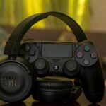 black Sony PS4 controller and JBL headphones