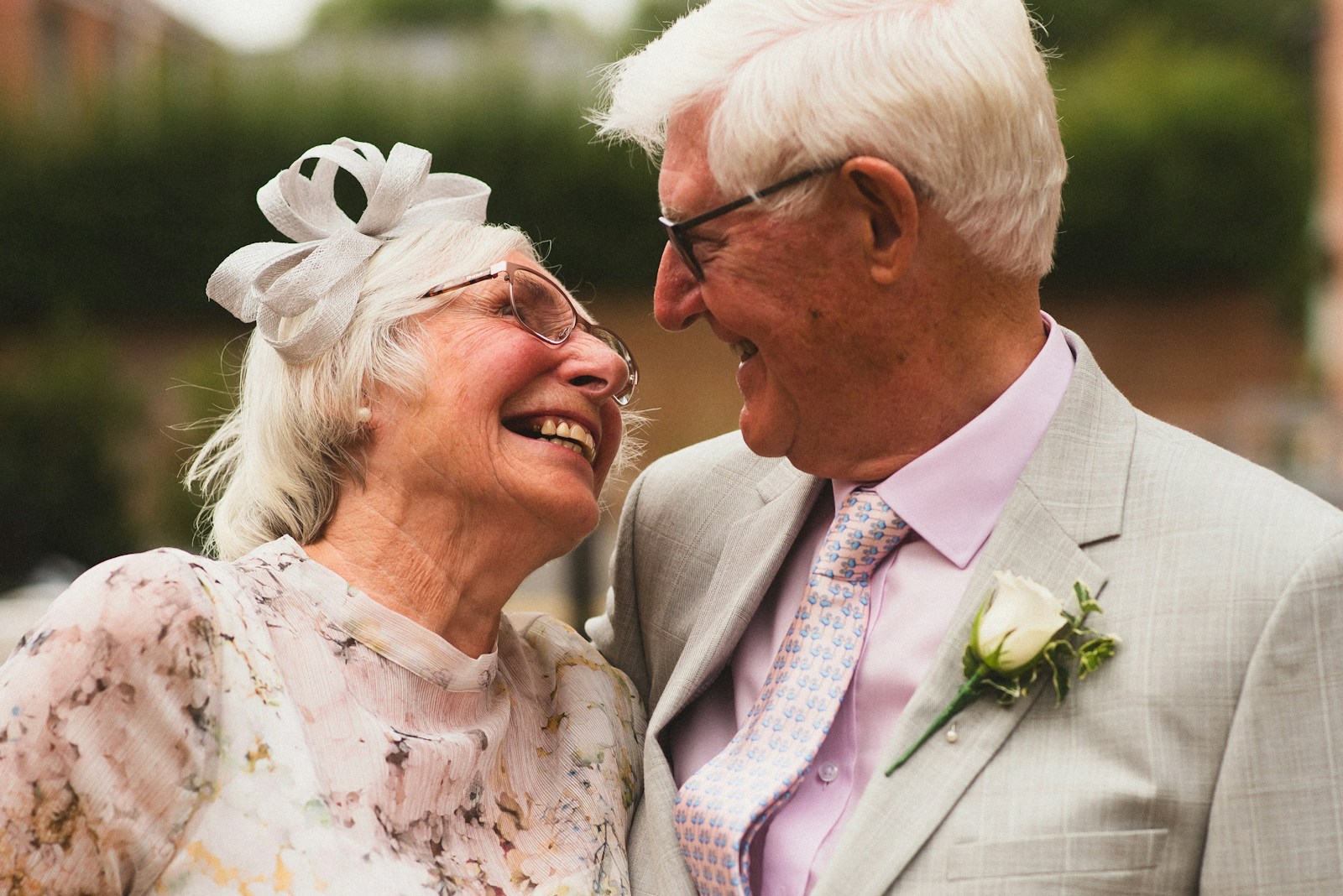 man in gray suit jacket beside woman in white floral dress