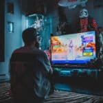 man in red shirt watching tv