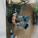 Woman working at a desk with laptop and bicycle.