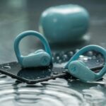 a pair of blue headphones sitting on top of a phone