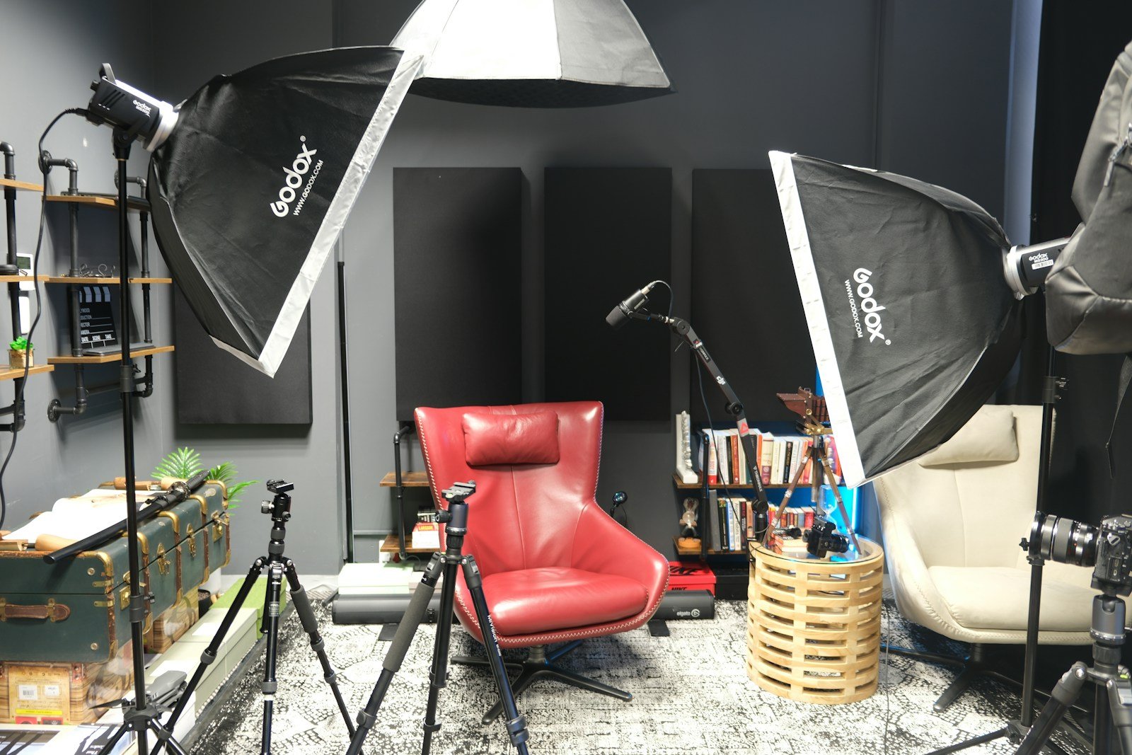 a photo studio with a red chair and umbrella