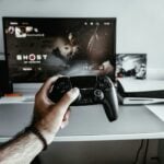 a person holding a video game controller in front of a tv