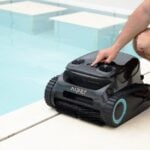 A person starts a robotic pool cleaner.