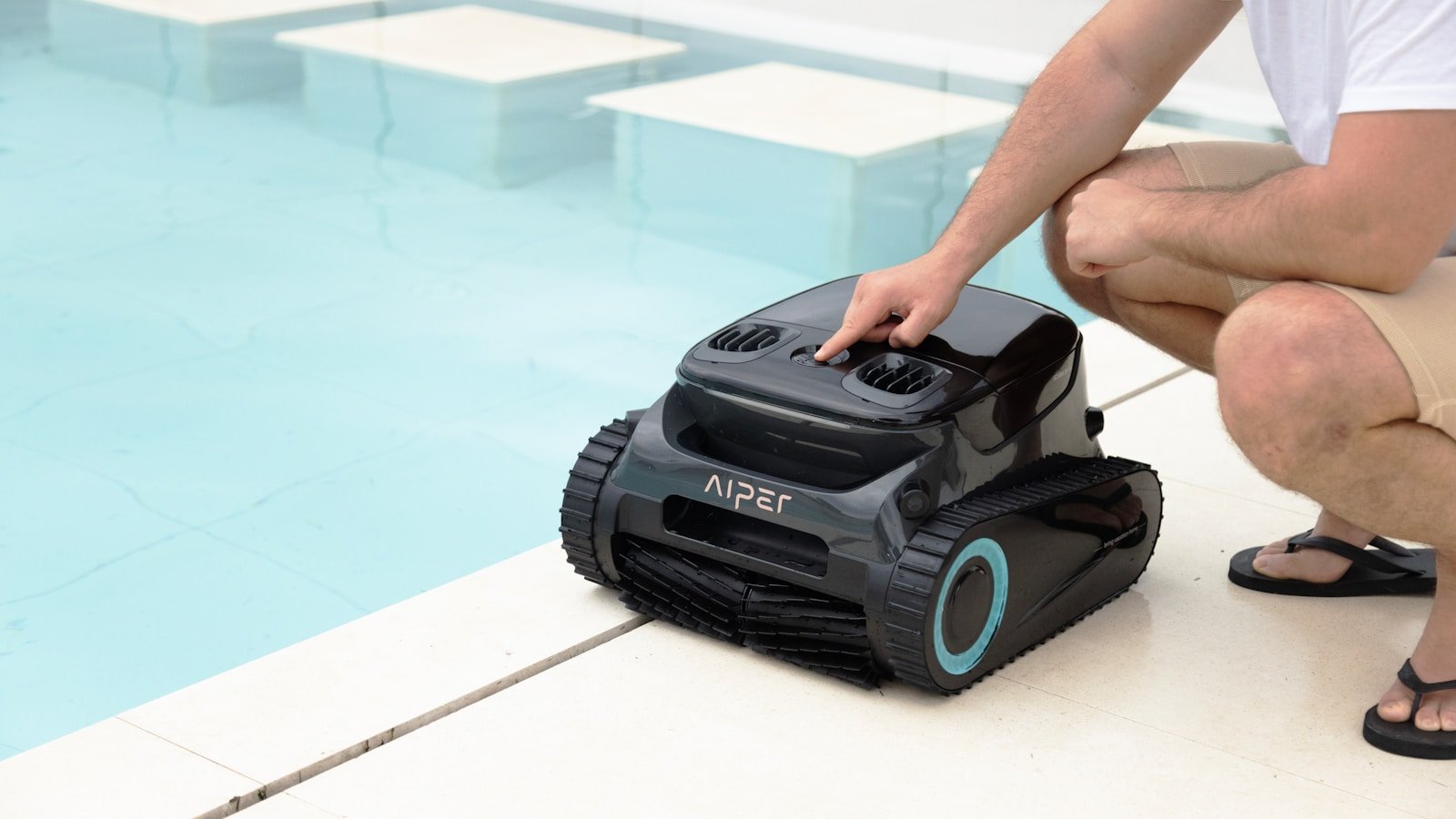 A person starts a robotic pool cleaner.