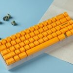 A yellow keyboard sitting on top of a piece of paper